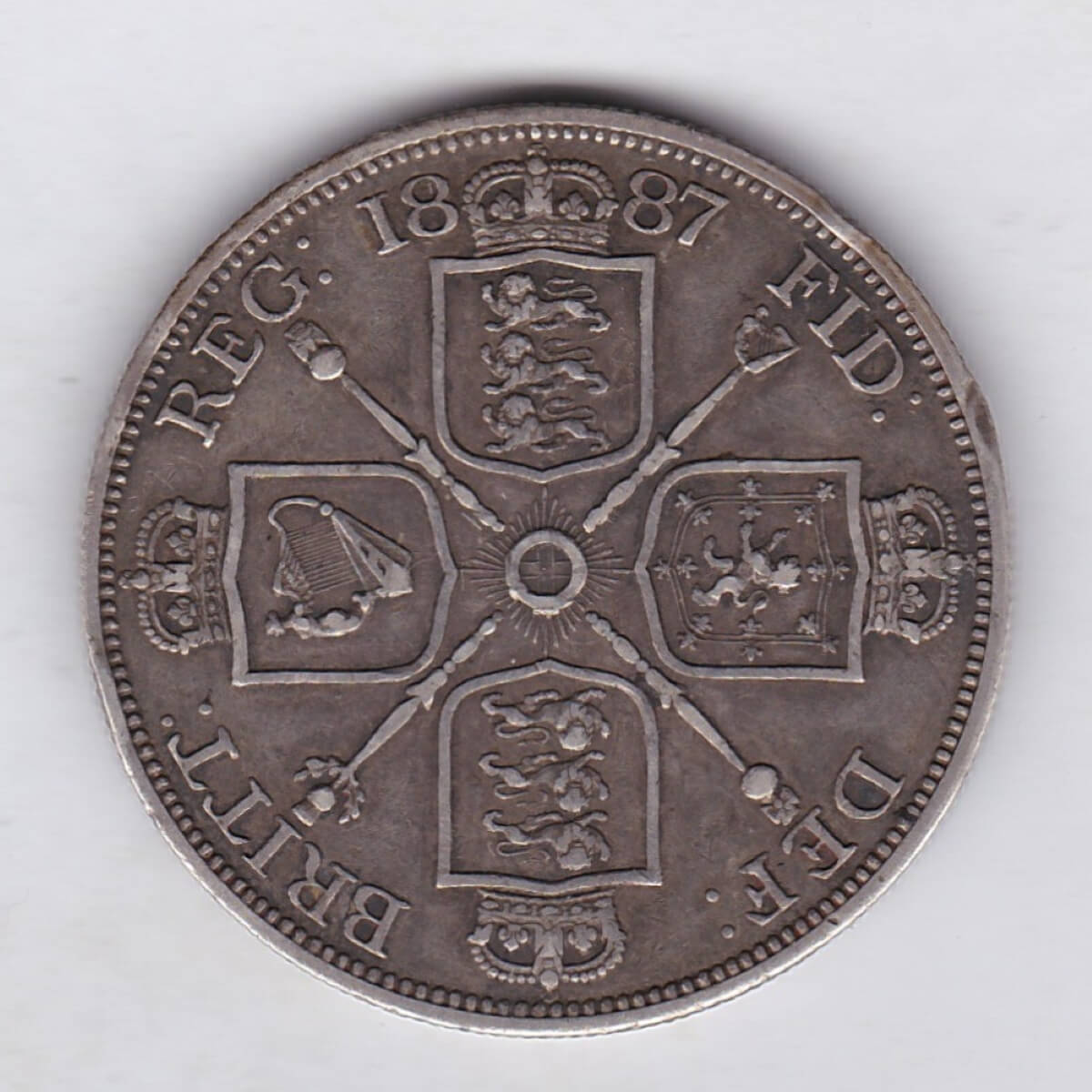 1887 silver double florin coin featuring the Jubilee Head design of Queen Victoria. With the Garter star and four sceptres in the angles Reverse.