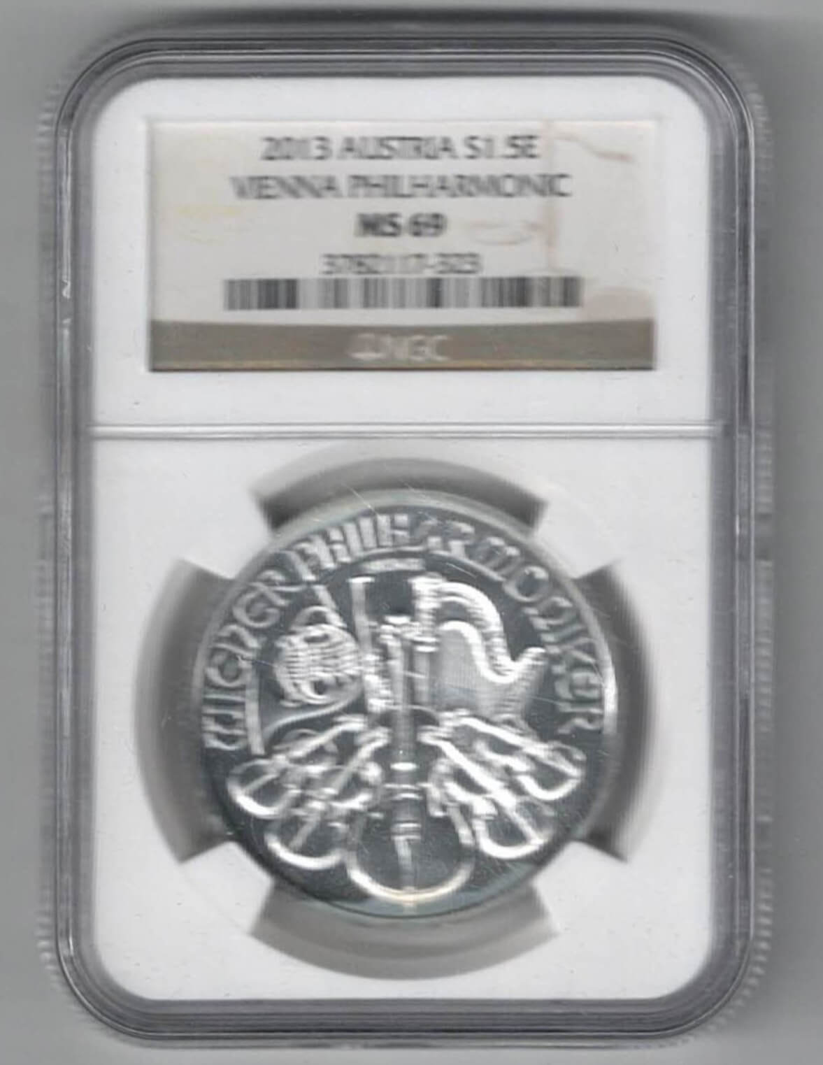 Slabbed NGC 2013 Silver Austria One Ounce Philharmonic Coin. This Coin does feature Music Instrument's The coin contains one ounce of 999 fine silver.